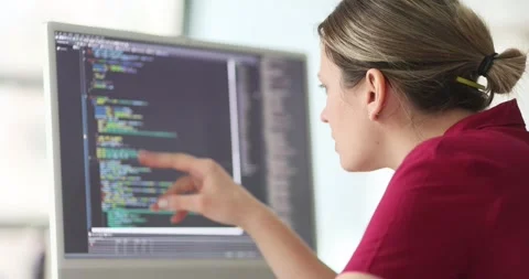 A focused programmer is diligently analyzing intricate code displayed on a Video stock 295057638