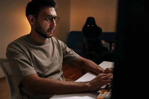 Focused programmer freelancer working on desktop computer late at night Stock-Fotos