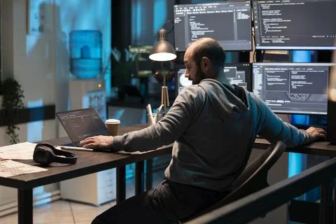 Focused Programmer Leaning Toward Multiple Coding Screens Stock-Fotos