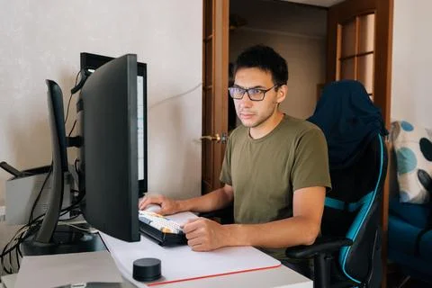 Focused programmer male typing on mechanical keyboard, working remotely from Stock Photos