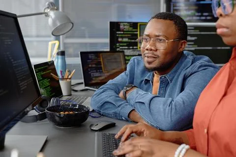 Focused Programmer Reviewing Trainees Code Searching for Bugs Stock Photos