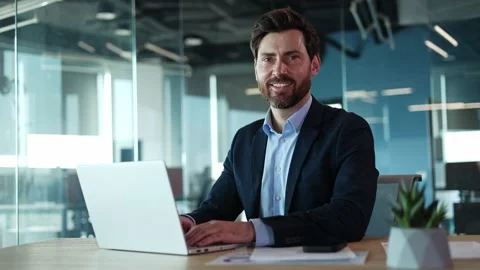 Focused programmer sitting by table and working by modern computer in office Video stock 271485415