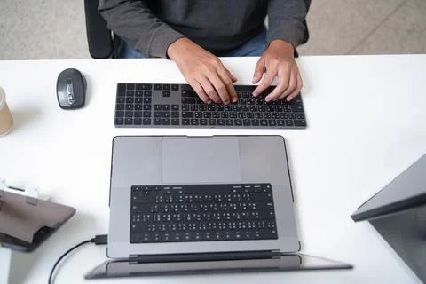 Focused Programmer Typing on Laptop in a Professional Setting Stock Photos