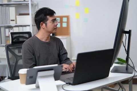 Focused Programmer Working on Code at a Desk Setup in a Professional Enviro.. Stock Photos