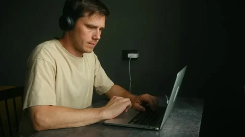 Focused programmer working on laptop with headphones Stock Footage 317905100