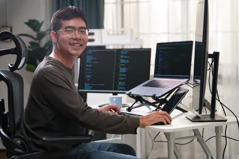 Focused Programmer Working with Multiple Monitors in a Productive Environment Stock Photos