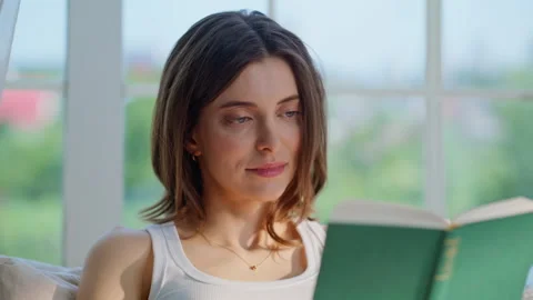 Focused reader looking book immersed in interesting story closeup. Relaxed woman Stock Footage 332703735