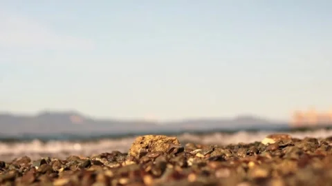 Focused Rocks with Sea Waves and Mountain Background Stock Footage 242140667