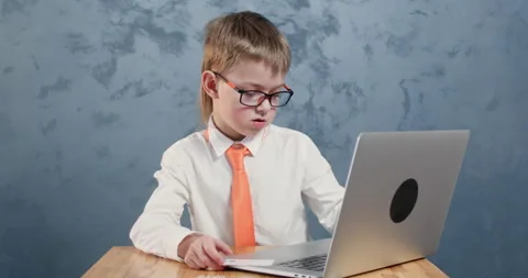 Focused schoolboy in tie inputs card information on laptop Stockbeeldmateriaal 304364945
