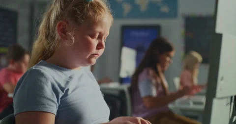 Focused Schoolgirl Using Computer in Modern Classroom Stock Footage 318075586