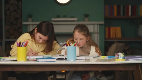 Focused schoolgirls prepare for an exam, doing homework and studying together Stock Footage 343423593