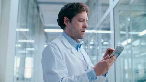 Focused Scientist Checking Research Data on Tablet in Medical Laboratory Stock Footage 332671054