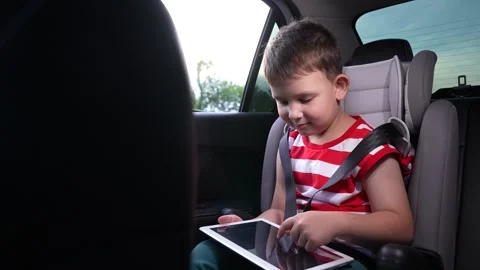 Focused on the screen, Young passenger in car, Keeping children busy, Relaxing Stock Footage 315221261