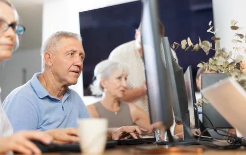 Focused senior man attending computer class for older adults Fotos de archivo