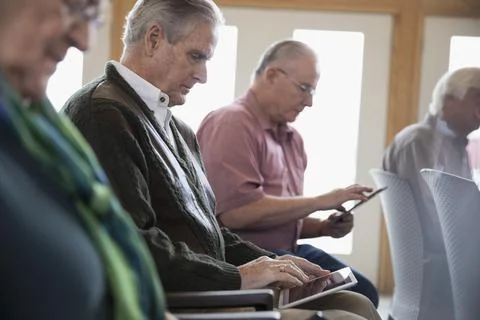 Focused senior man student using digital tablet in classroom 스톡 사진