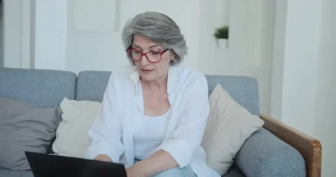 Focused senior woman using computer for research and creative work Stock Footage 159168077
