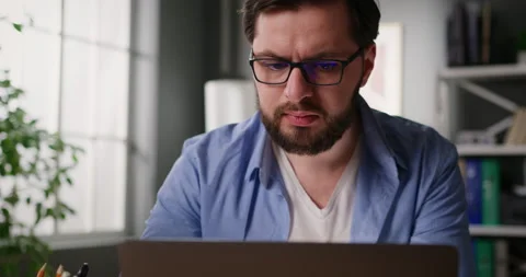 Focused serious businessman looking at computer screen working on laptop at home Video stock 151100031