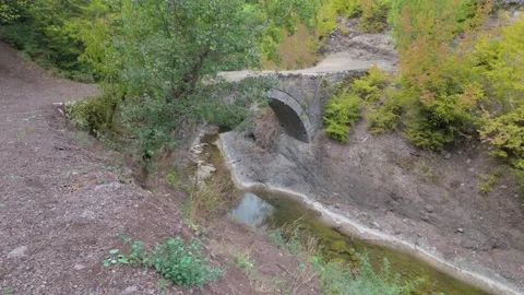 Focused shot on centuries old stone bridge over the creek 動画素材 346898920
