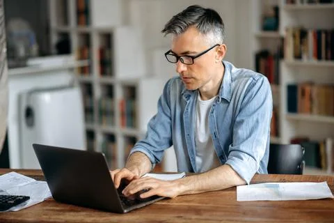 Focused smart successful gray-haired senior caucasian man wearing glasses Stock Photos