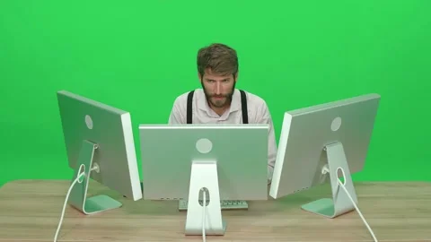 Focused software developer working on a PC while sitting at a desk, green Stock Footage 234858761