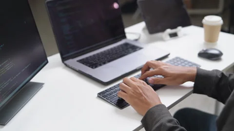 Focused Software Developer Working Remotely on Laptop with Multiple Screens.. Stock Footage 336679912