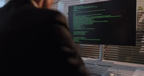 Focused software developer writing code on computer monitor in corporate office 库存影片 330509423