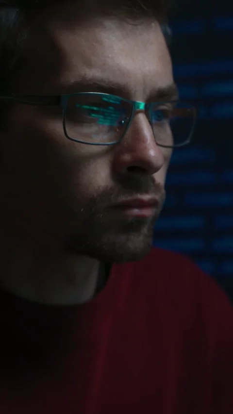 Focused software engineer working at a dark office desk late at night Stock Footage 345446255