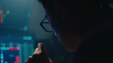 Focused stock trader analyzing market data on computer screens at night Stock Footage 329086898