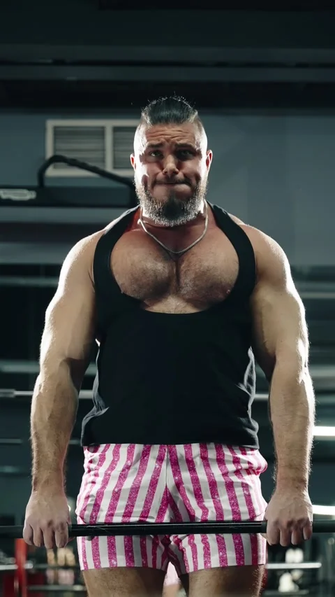 Focused strength athlete straining through a heavy lift in a modern gym Video stock 329556619