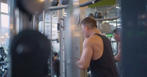 Focused on strength, the man performs triceps exercises to build muscle and tone Video stock 321827854