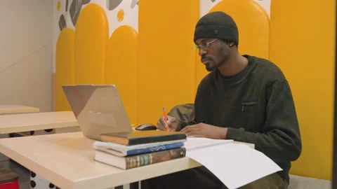 Focused student multitasking in study environment. Diligent young person Stock Footage 333184937