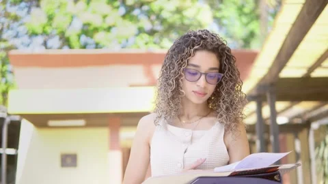 Focused student reviewing her notes on campus Video stock 328608734