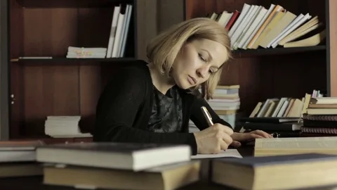 Focused student studying in the library in college. Female student sitting at Stock Footage 74872556