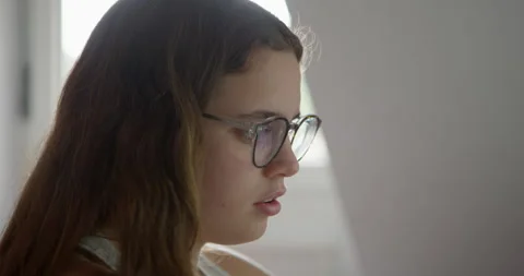 Focused Student Studying: A young student wearing glasses. Stockbeeldmateriaal 336407089