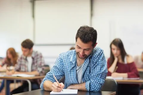 Focused student taking notes in class Stock Photos