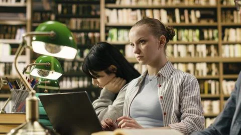 Focused student typing and taking notes on laptop for university assignment Stock Photos