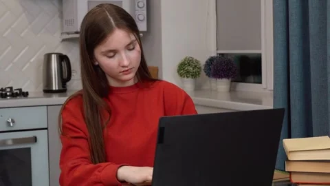 Focused student typing on laptop, studying at home 스톡 동영상 311813106