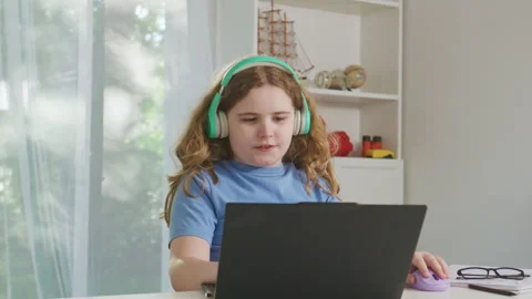 Focused student using a computer. Student studying with headphones during online Stock Footage 345542876
