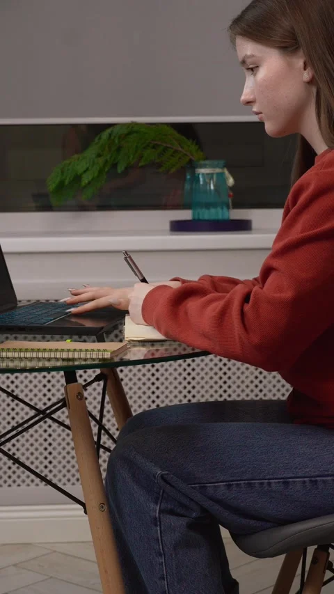 Focused student working on laptop at home Vídeos de archivo 311813337