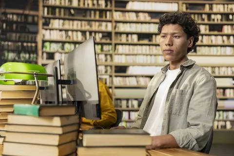 Focused student works at desktop computer in library study area Stock Photos