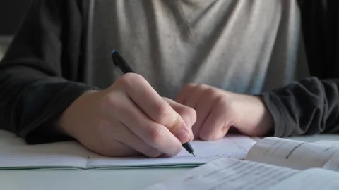 Focused student writing exam notes Stock Footage 338384566
