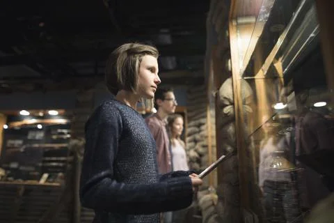 Focused students looking at exhibit in dark war museum Stock Photos