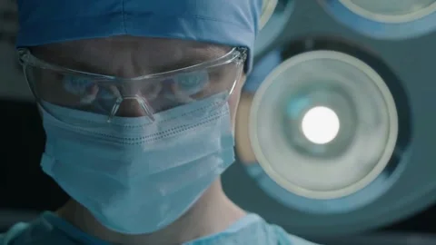 Focused Surgeon Under Operating Room Lights Stock Footage 314303324