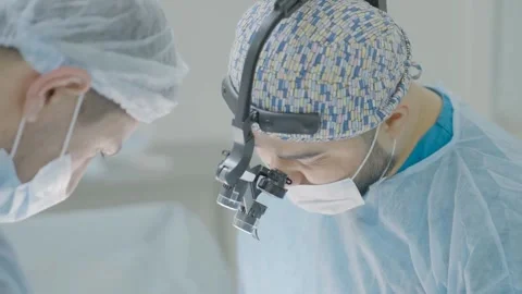 Focused Surgeons Performing Procedure Under Anesthesia in Operating Room Stock Footage 314303347
