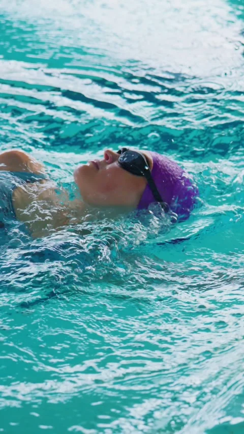 Focused swimmer moves smoothly in pool, arm raised high Stock Footage 346459139