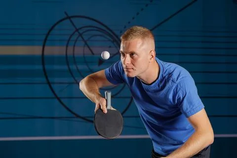 Focused table tennis player preparing a serve with ball in midair indoors Stock Photos