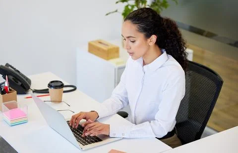 Focused on the task at hand. an attractive young businesswoman sitting alone in Stock Photos