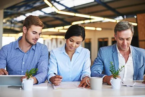 Focused on the task at hand. smiling colleagues working together in an office. Stock Photos