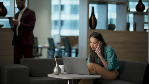 Focused team lead working laptop computer in office. Woman talking smartphone Stock-Footage 225629333