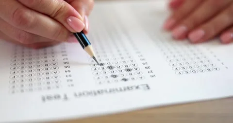 Focused test taker fills answer sheet with pencil during exam Stock Footage 312934268